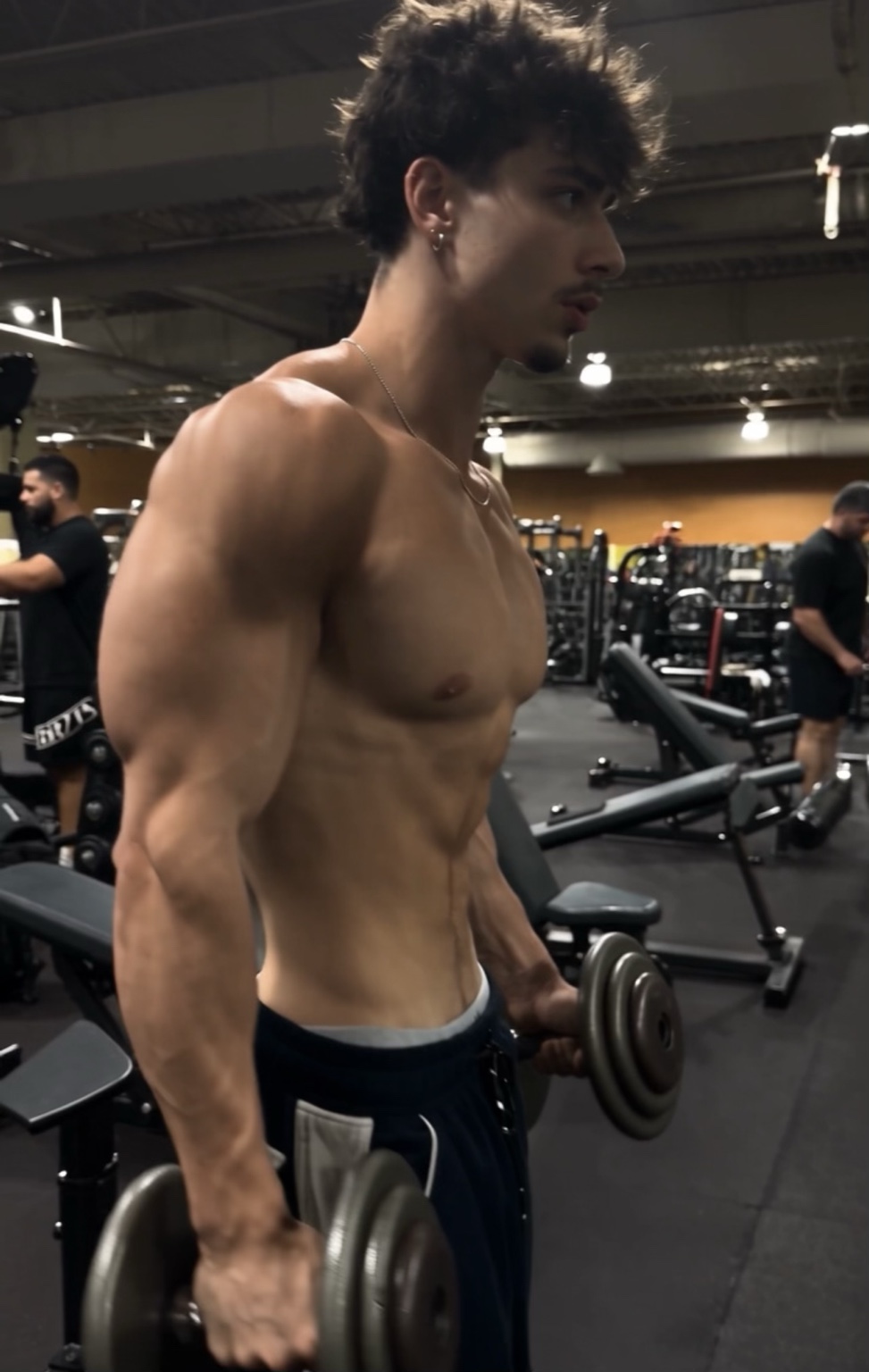 Person holding dumbbells in a gym